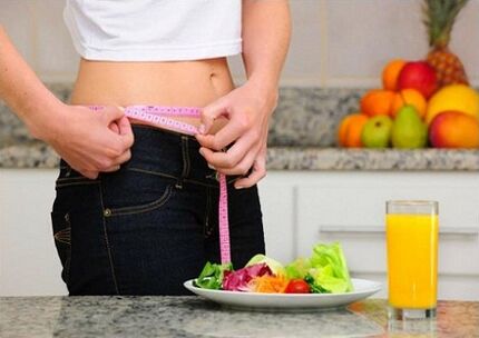 Una niña que pierde peso con una dieta mide el tamaño de su cintura.
